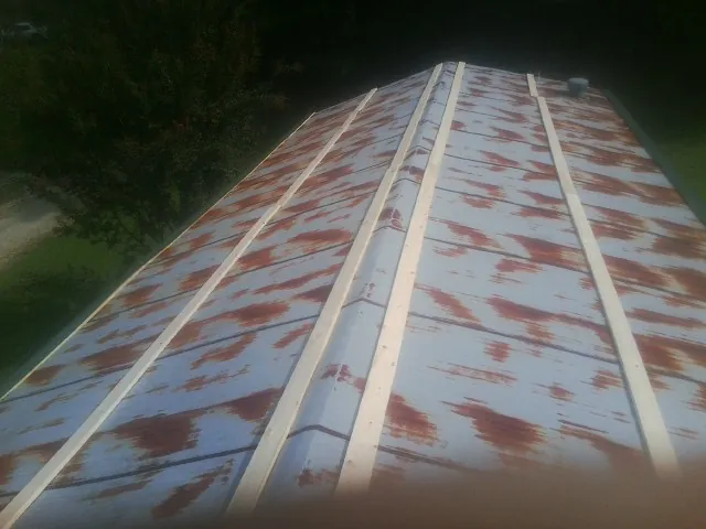 Rusted metal roof panels with new wood purlins before replacement — Storm Damage Roof Repair in Pinellas Park by Roofing Brothers