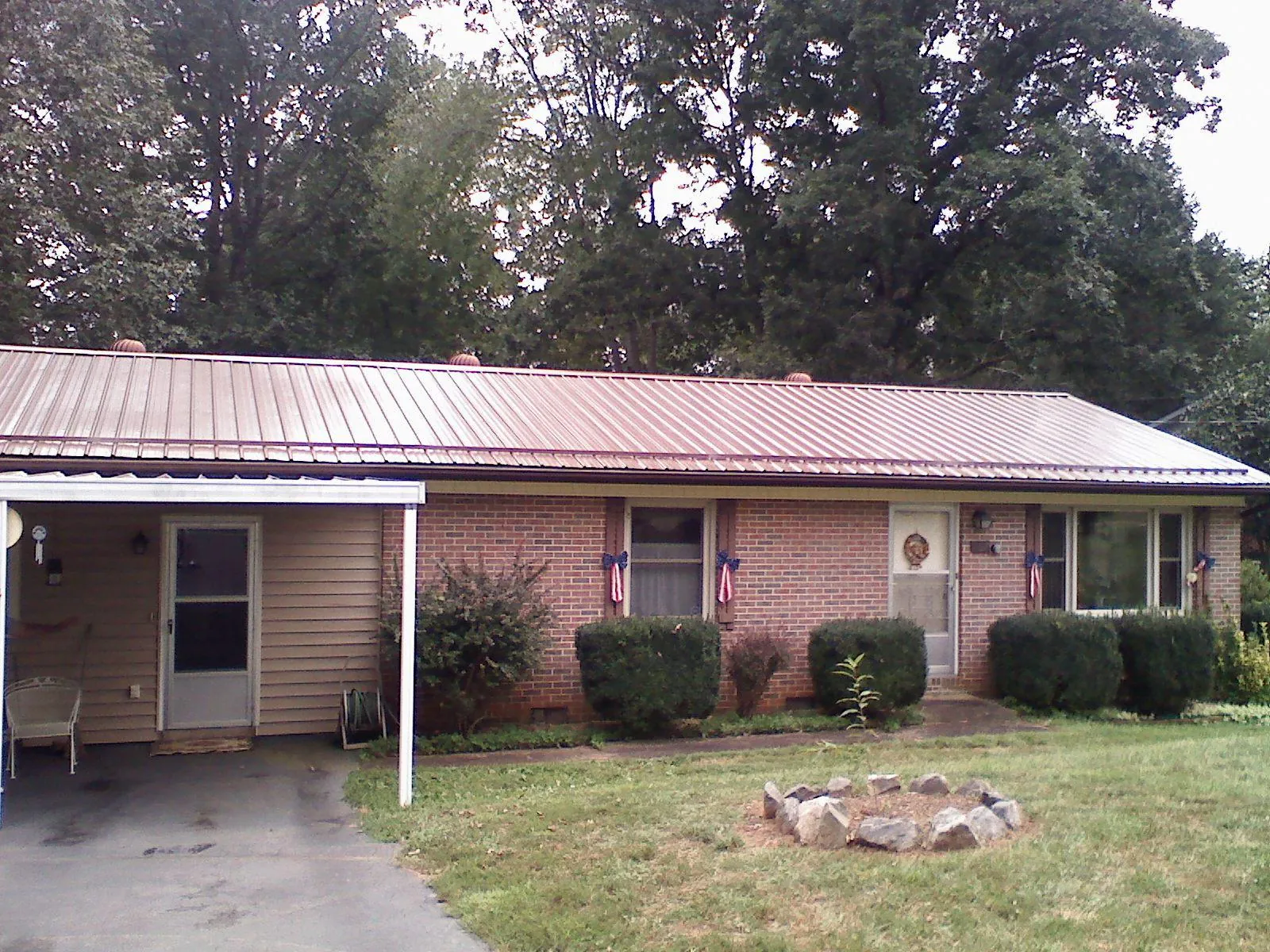 Bronze metal roof and carport on a brick ranch home — Roof Repair work by our crew in Pinellas Park